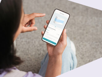 Person hält ein Smartphone und zeigt mit dem Finger darauf, Ansicht von hinten.