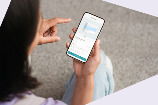 Person hält ein Smartphone und zeigt mit dem Finger darauf, Ansicht von hinten.